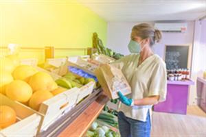 Femme achetant des légumes dans un magasin de producteurs pendant la période du COVID